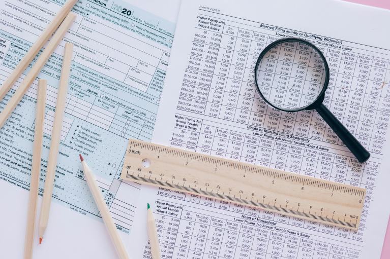 Tax Forms with Pencils, a Magnifying Glass, and a Ruler